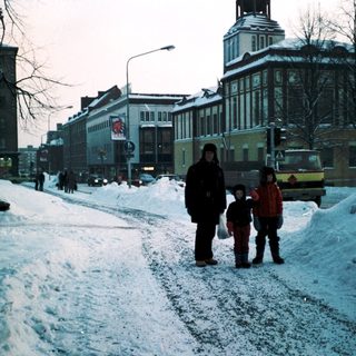 Snowy city street with people walking.