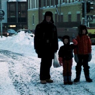 Snowy city street with people walking.