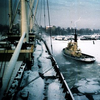 Icebreaker vessel navigating partially frozen harbor waters.