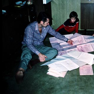 Family sorting or organizing paperwork together indoors.