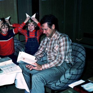 Family enjoying holiday with cat-ear headbands indoors.