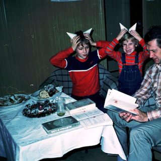 Family enjoying holiday with cat-ear headbands indoors.