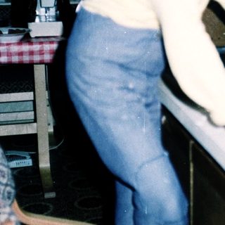 Young girl cutting food at kitchen counter.