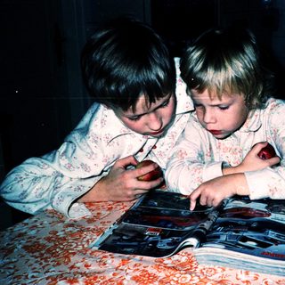 Two children intently reading a book together.