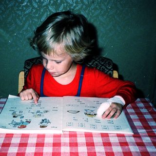 Child playing with board game at table.