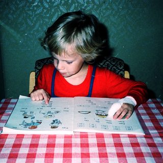 Child playing with board game at table.