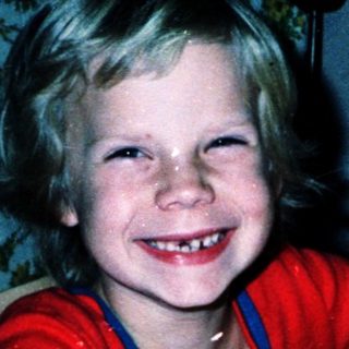 Young child happily writing at a desk.
