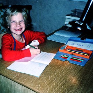 Young child happily writing at a desk.