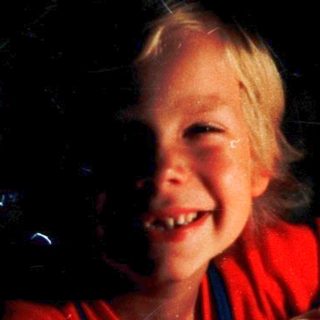 Child happily drawing with colored pencils.