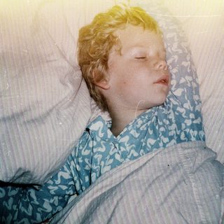 Child peacefully sleeping in hospital gown.