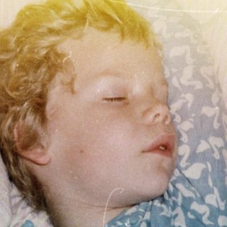 Child peacefully sleeping in hospital gown.