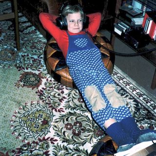 Child relaxing with headphones on indoors.