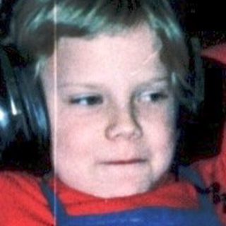 Child relaxing with headphones on indoors.