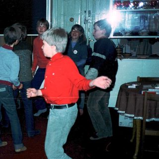 Group of children playing indoors with flashlight.