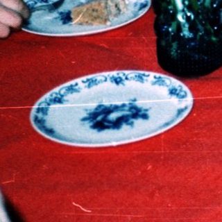 Children gathered around a table eating cake.