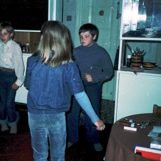 Group of children playing indoors during evening.