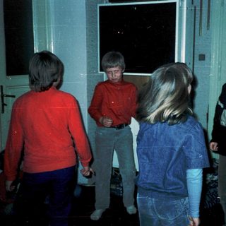 Four children playing indoors near a window.