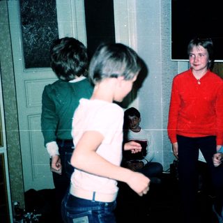 Four teens playing indoors, laughing together.