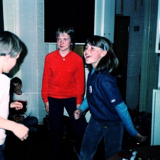 Four teens playing indoors, laughing together.