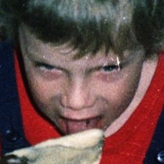 Child mixing batter in a bowl indoors.