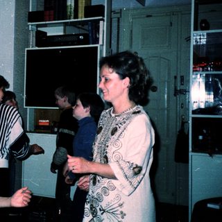 Family gathering in retro kitchen with gaming console.