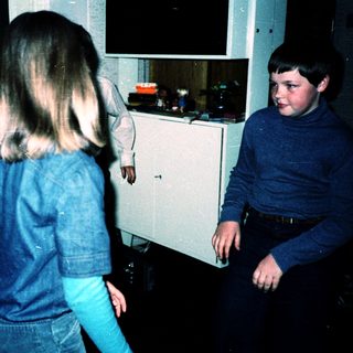 Four children playing indoors at night.