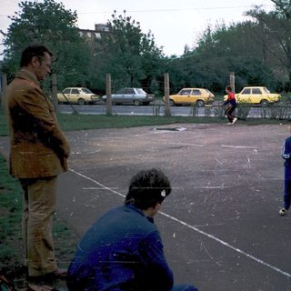 Children playing basketball on outdoor court.