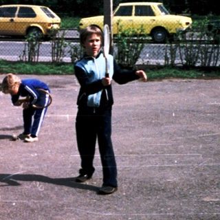 Police officers supervising children playing on a marked court.