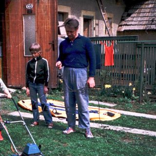 Family mowing lawn together outdoors.