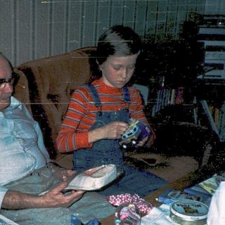 Family enjoying gift exchange indoors.