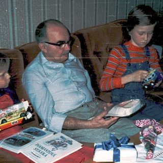 Family enjoying gift exchange indoors.