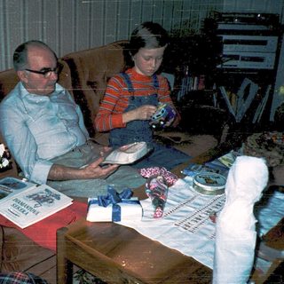 Family enjoying gift exchange indoors.