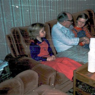 Family enjoying holiday gift opening indoors.