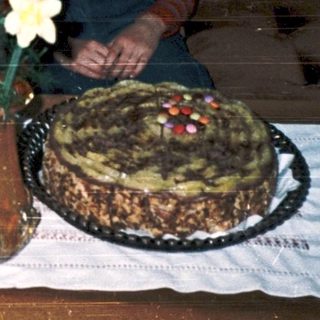 Family celebrating birthday with gifts and cake.
