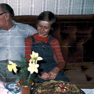 Family celebrating birthday with gifts and cake.