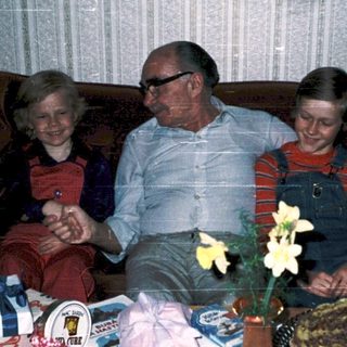Family celebrating birthday with gifts and cake.