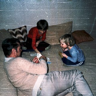 Family playing cards indoors together.