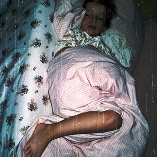 Person lying in bed with advanced pregnancy.