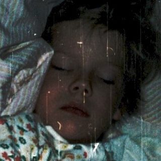 Person lying in bed with advanced pregnancy.
