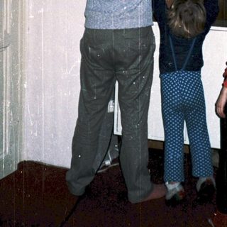 Family installing large glass door panel together.