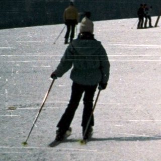 People skiing on snowy mountain slope.