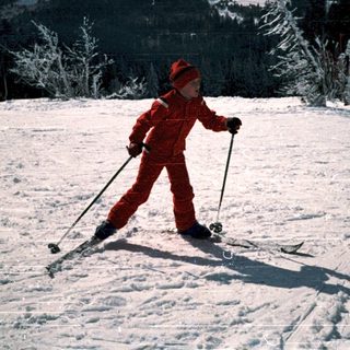 Child cross-country skiing on snow-covered trail.