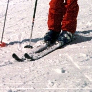 Two children skiing on snowy mountain slope.