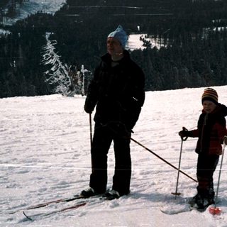 Two people skiing on snow-covered slope.