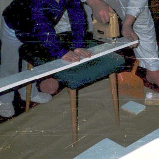 Children helping repair flooded floor with wooden planks.