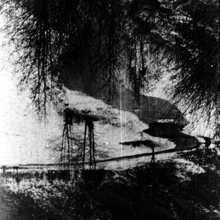 Snow-covered river winding through forested landscape.