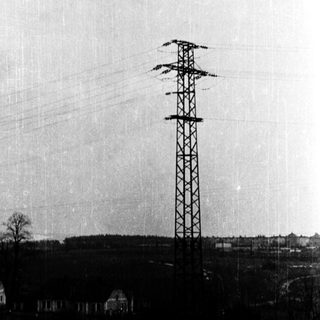 Urban landscape with power tower and transmission lines.