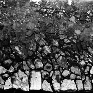 Dry-stone wall with irregularly fitted stones.