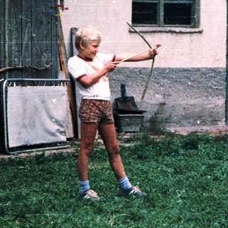 Children playing with baseball bats outdoors.