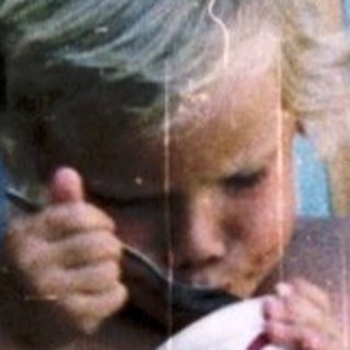 Young child eating ice cream on beach chair.